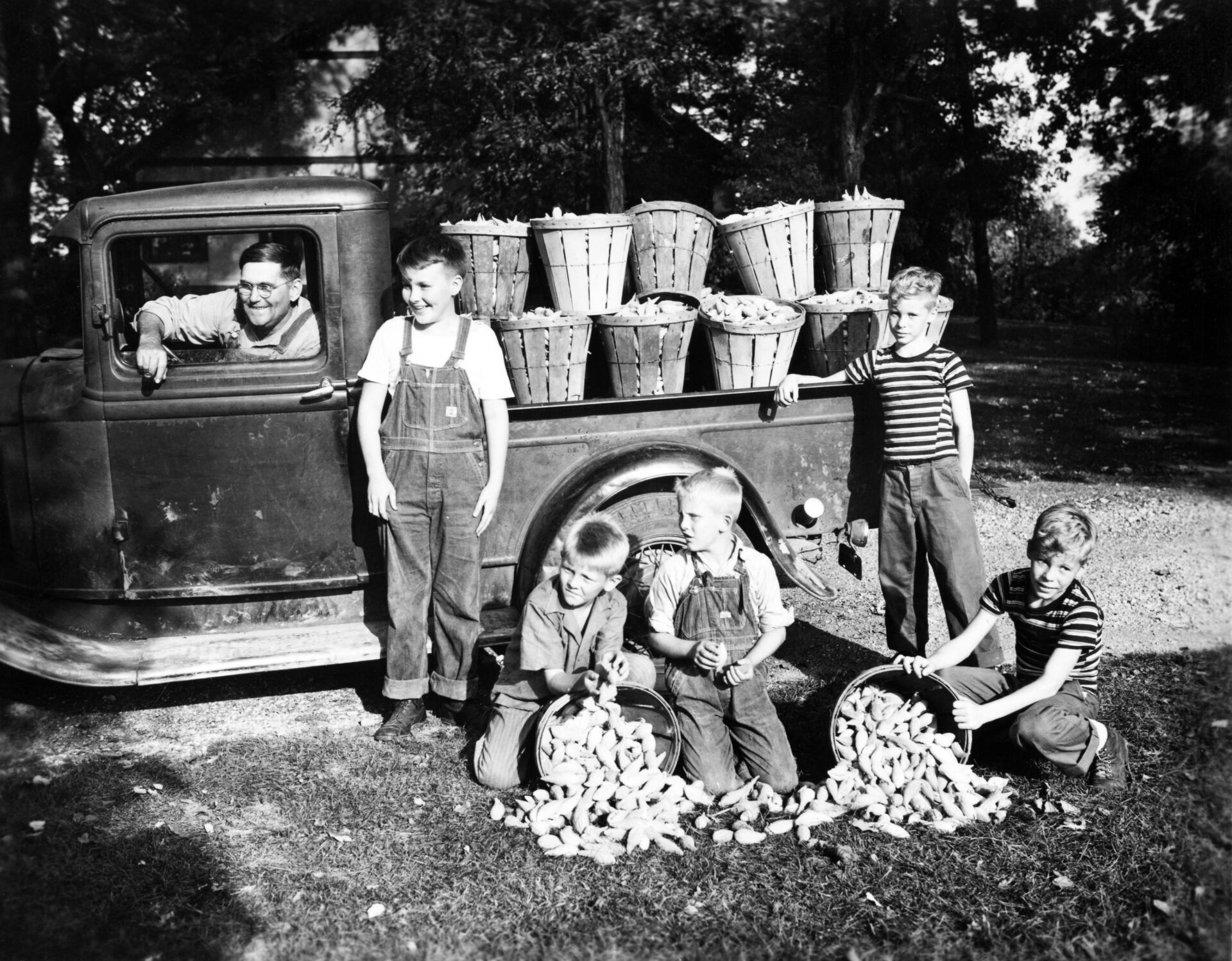 Children sitting near a car