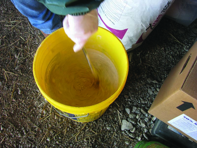 mixing herbicides in a bucket 