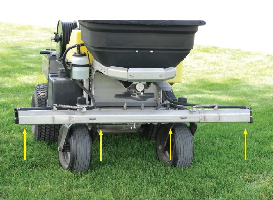 A boom-type ride-on sprayer/spreader with four nozzles. Arrows point to nozzle placement.