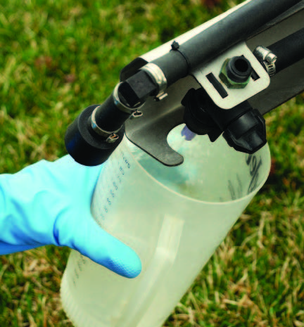 Person measuring the number of fluid ounces delivered from each nozzle for the length of time it took to travel the calibration course.