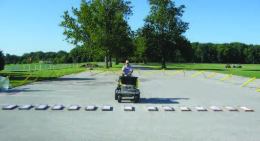 The center box is marked with an arrow. Notice the extra space on either side of the center box to allow room for the wheels. In this example, the spreader is being calibrated for a product with a large granule, so the boxes are placed about 12 inches apart to catch the granules along the entire width of the spread.