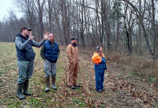 4 forestry or wildlife professionals evaluating the property