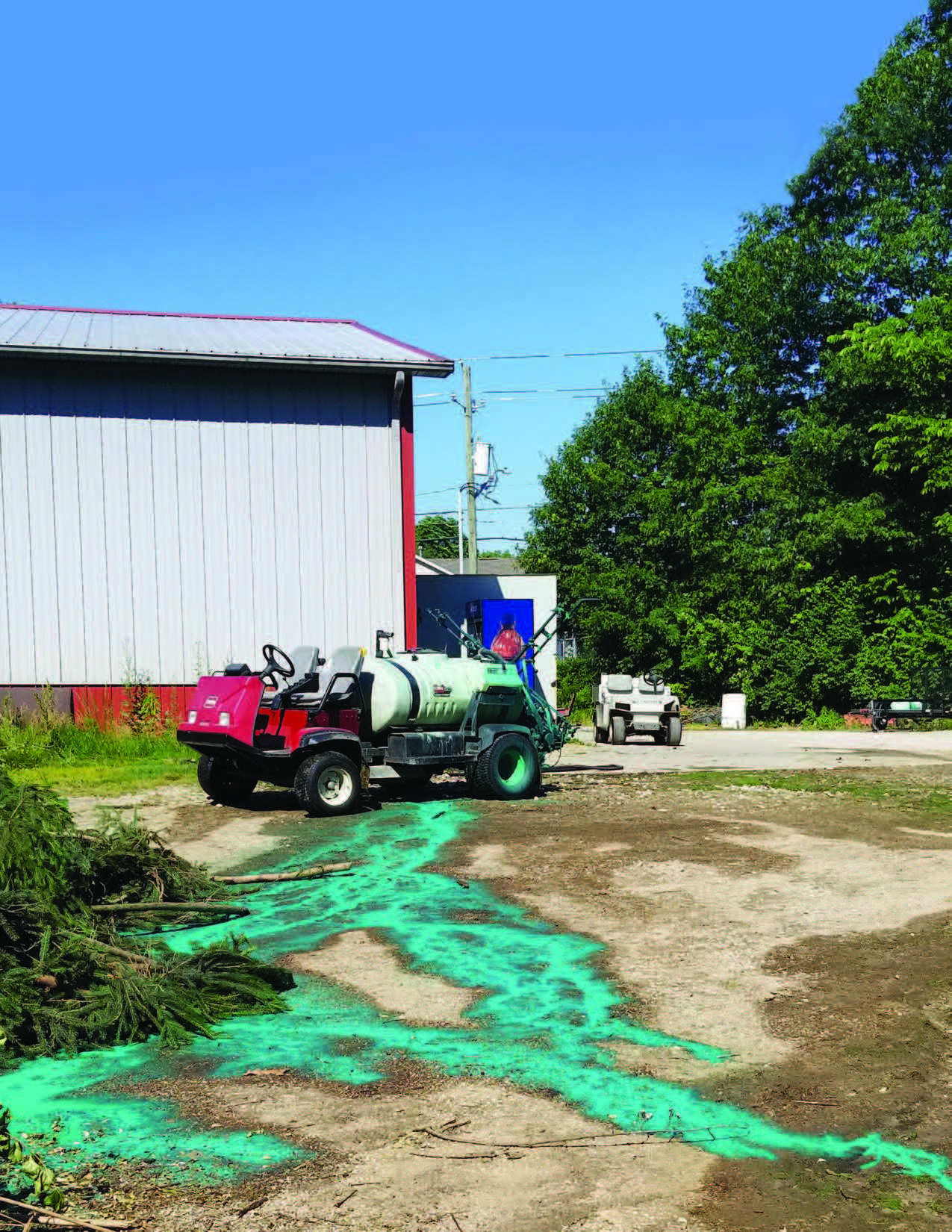 Cover page with greenish material running down the hill toward a ditch.