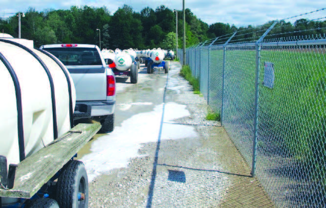 large nurse tank with discolored liquid gushing onto the ground