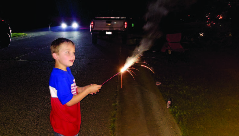 Child playing with sparkler fireworks