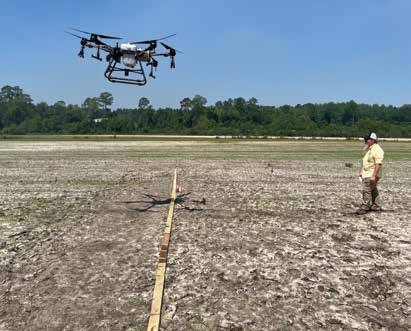 An inexpensive and practical way to determine effective spray width, spray uniformity, and spray drift is to use water sensitive paper (WSP). Here, the applicator fastened WSP to boards laying on the ground perpendicular to the drone flight path. Operators can use the information from the WSP to adjust the settings (height, speed, etc.) that determine effective spray swath.