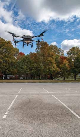 A drone spraying 10 feet above pavement.