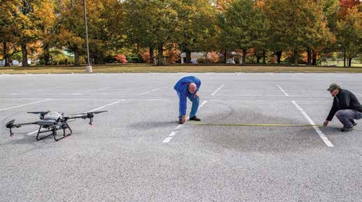 2 people measuring the spray width