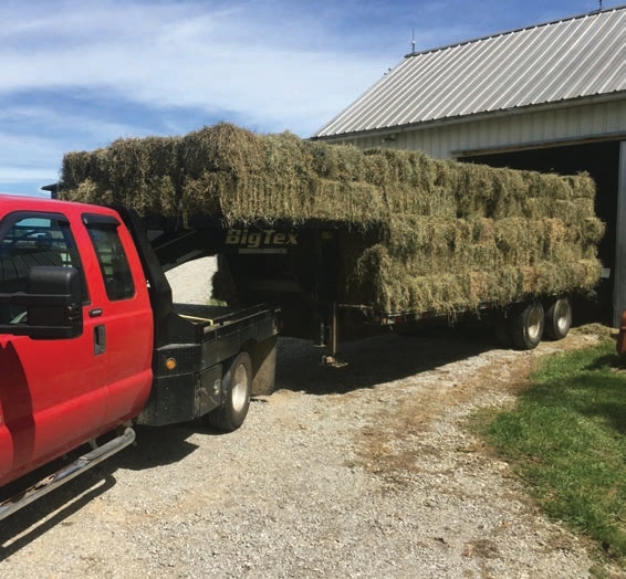 The deck has a rail that keeps the lower tiers of rectangular bales in place, but the top two levels are not contained by that railing.