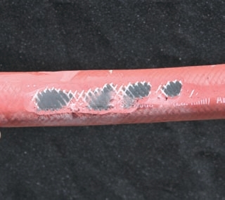 These photos show hoses worn from rubbing. Even covers might not protect underlying hose layers as shown in the photo of the orange hose.