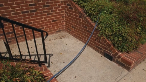 Running hoses over sidewalks or other high-traffic areas can damage the hoses or injure people who might trip over them.