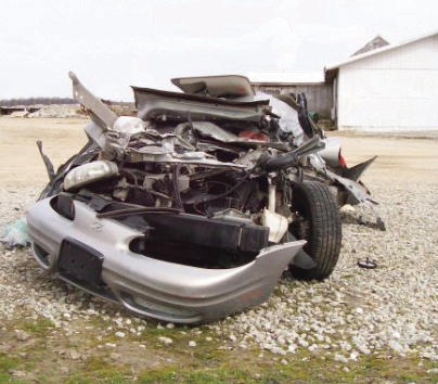 This car failed to stop at an intersection. The tractor ran over the car and killed its driver.
