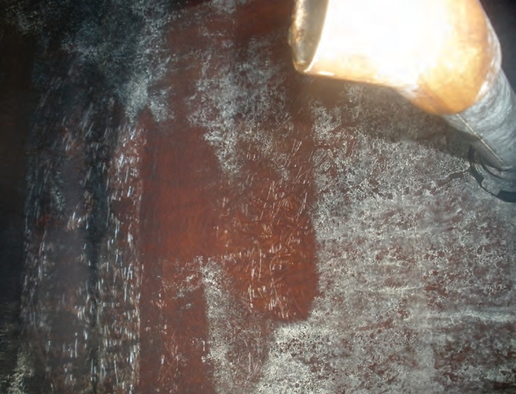 This used truckmounted fiberglass tank is up for sale. Its inside sidewalls have been wiped clean of residue (red circular patch), and the fibers appear to still be embedded into the resin, suggesting that the products carried in the tank have not hurt the resin.