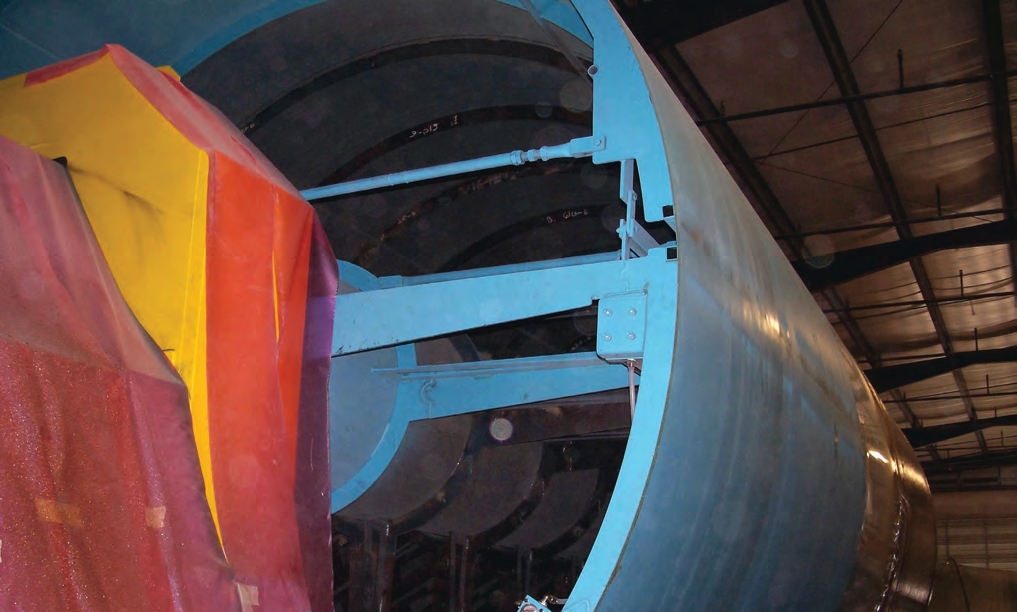 This photo shows the inside of the mold (foreground) and the brown fiberglass tank attached to it (background). Once the tank dries, the mold will contract and allow the tank to be removed.