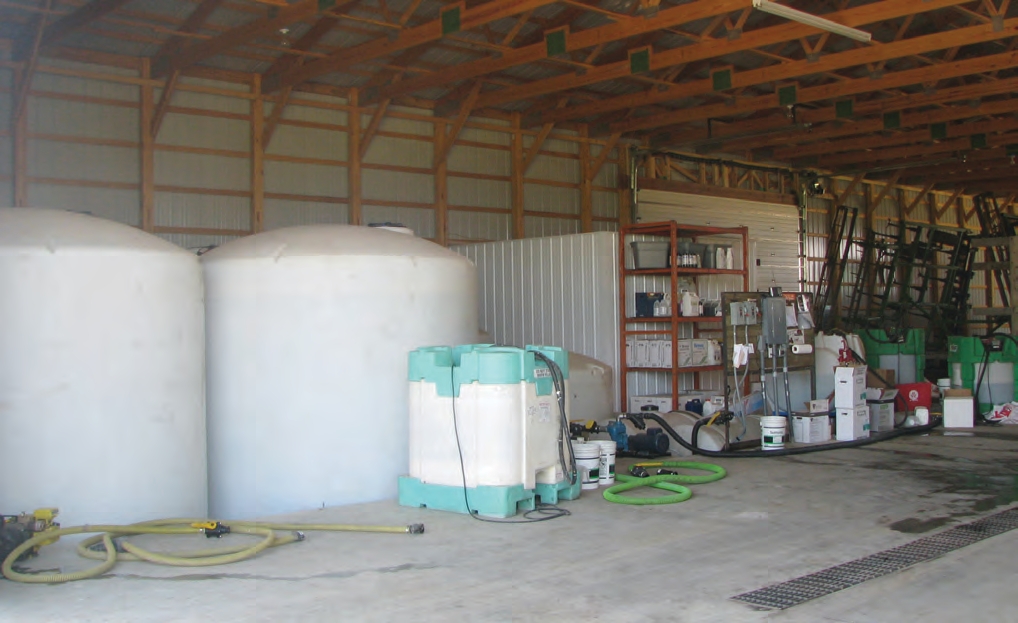 The large white storage tanks are contained in a concrete pit that goes below ground level.