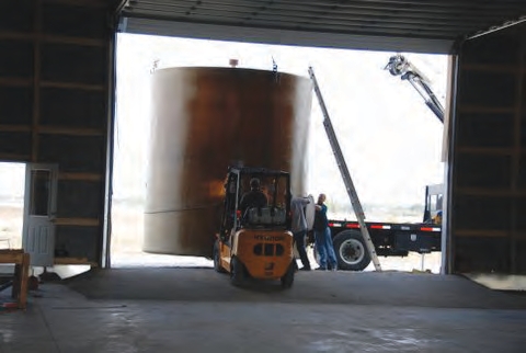 forklift or front-end loader to position the tank and place it upright once it is unloaded.