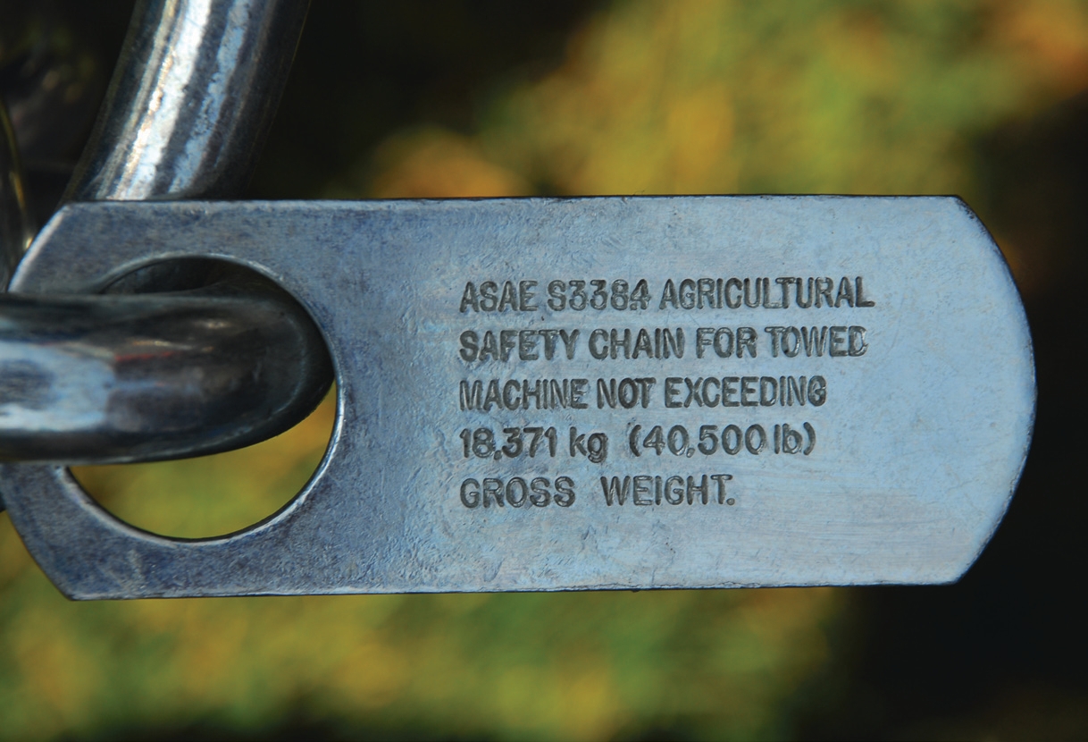 Safety chains permanently fastened to farm implements, which indicate that the towed implement should not exceed a specific gross weight.