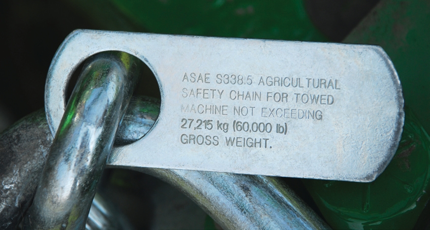 Safety chains permanently fastened to farm implements, which indicate that the towed implement should not exceed a specific gross weight.