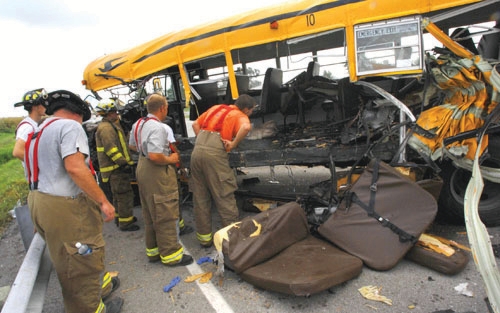 firefighters investigating a truck accident with a school bus