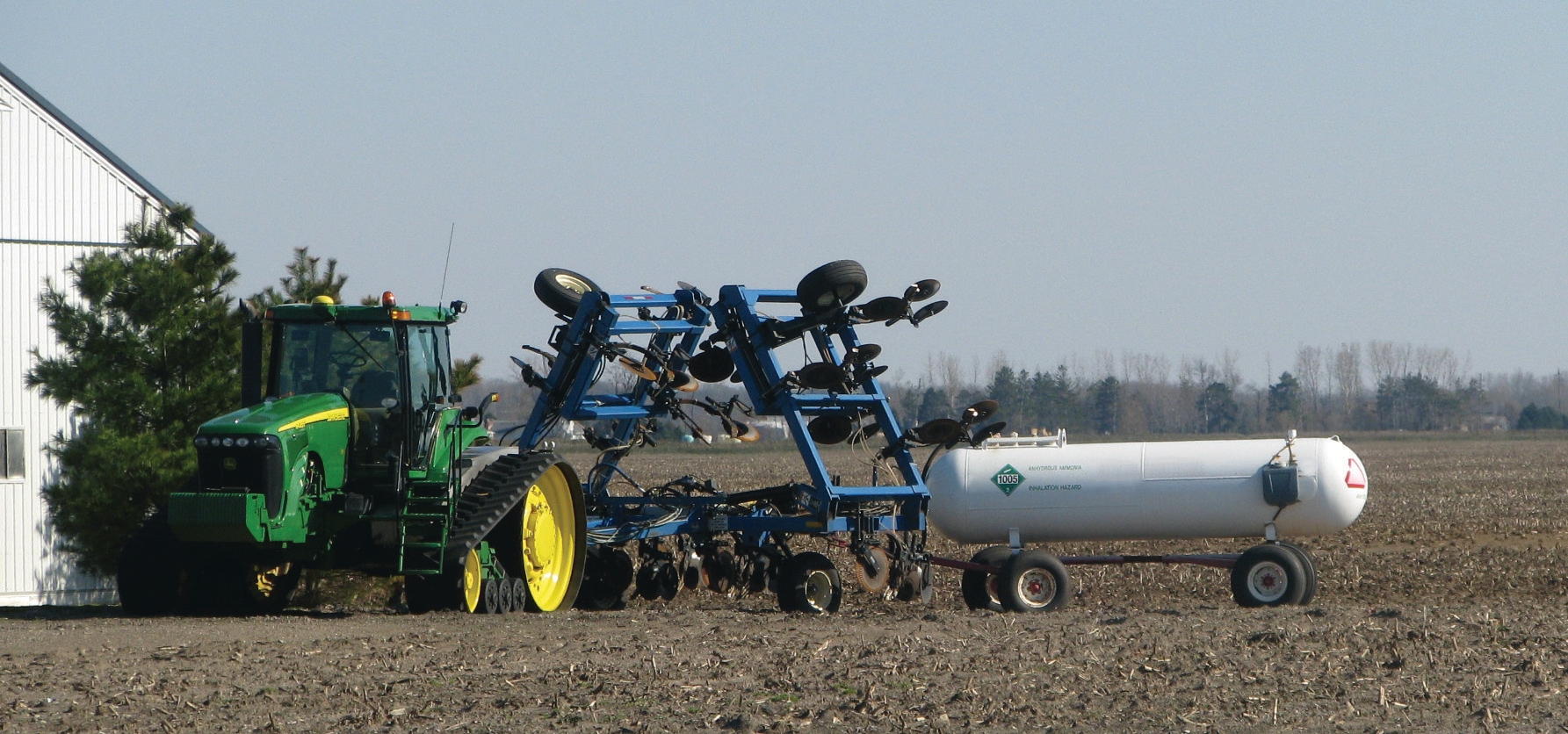 A tractor pulling multiple implements and trailers