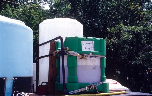 Pesticide containers secured to trailer to prevent rolling and sliding.
