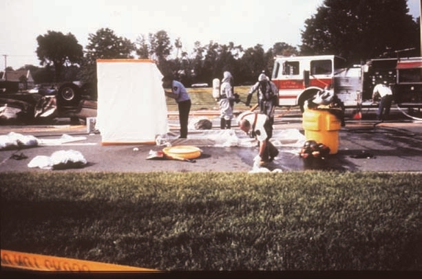Workers cleaning a ppesticide spill on the road