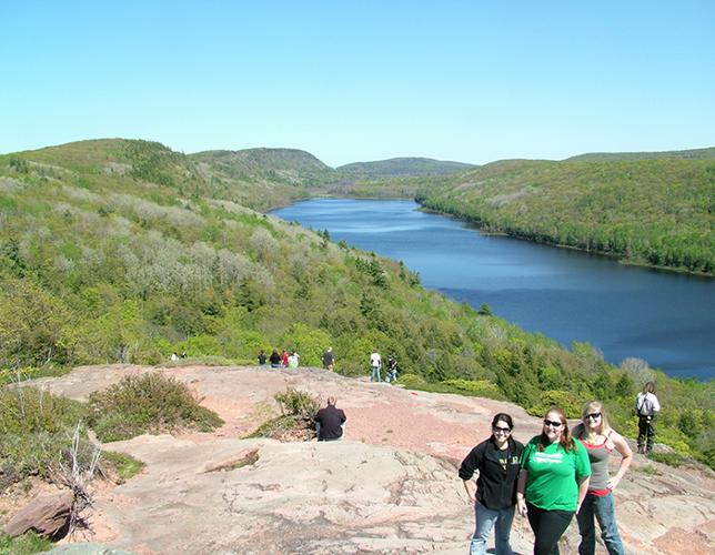 Summer Practicum students on hillside with lake below.