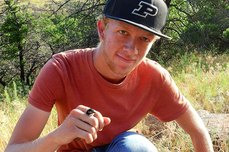 Landon Neumann, wildlife student, holding salamander.