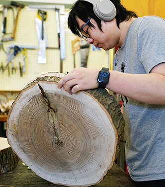 Wood products student working with wood slice in Wood Products Lab.