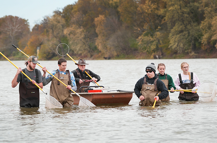 Aquatic sciences' students in river with nets conducting research with Professor Reuben Goforth.