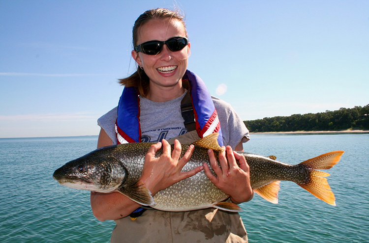 Aquatic Science student holding fish in the Great Lakes.