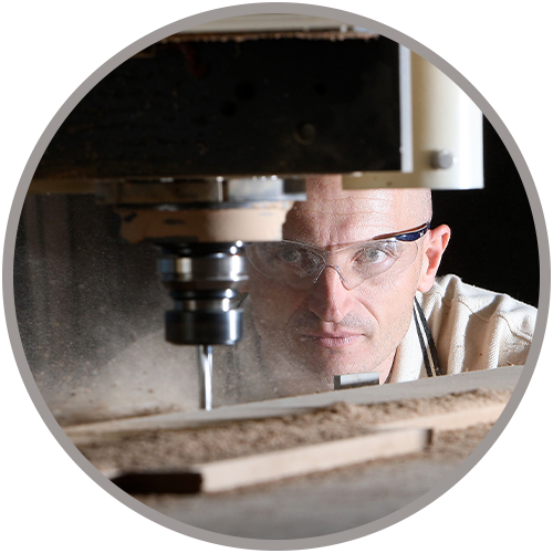 Person cutting wood in a machine