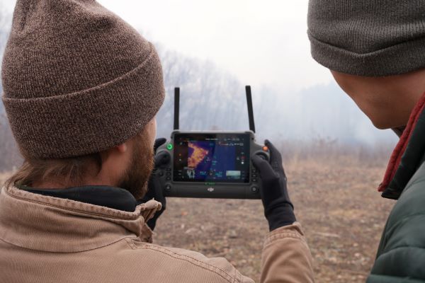 Students with drone controller as they view prescribed burn.
