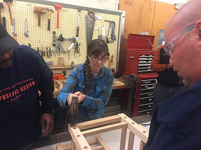 Dr. Eva Haviarova demonstrates woodworking at Purposeful Designs, a company that trains men with a troubled past.