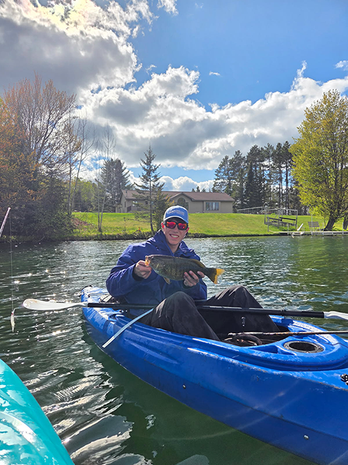 Colin Frost on a kayak on a lake.