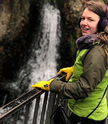 Marissa Cubbage standing next to waterfall.