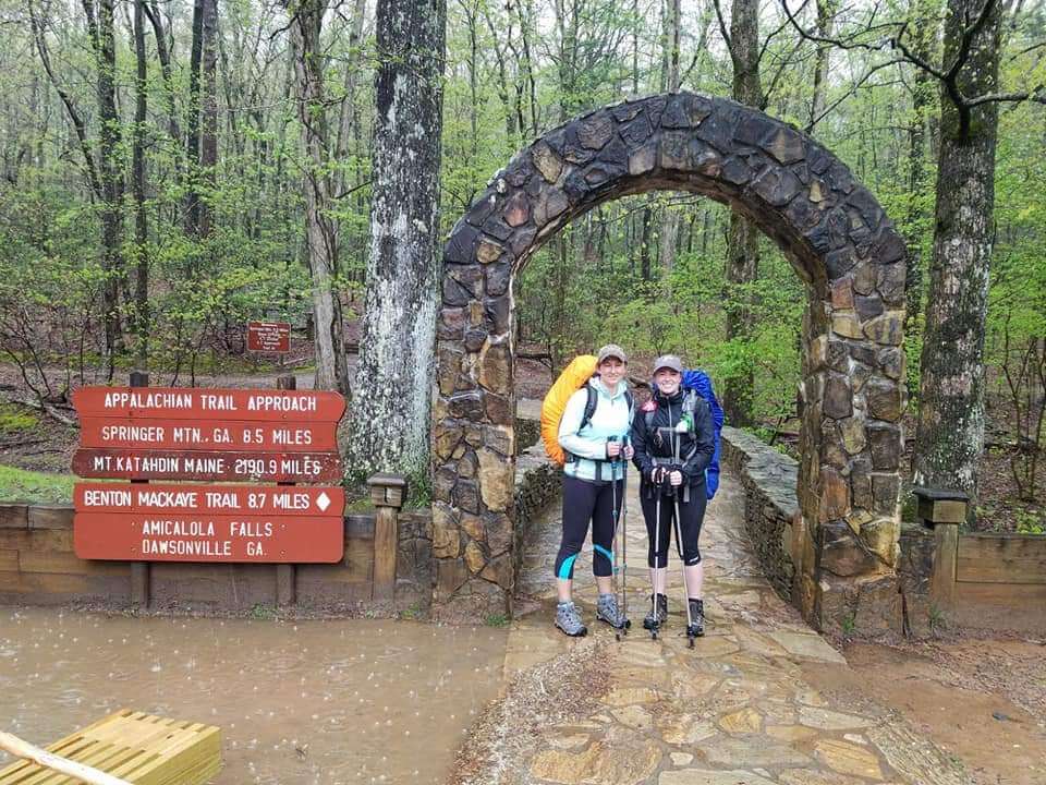 Rebekah Lumkes and Baleigh Haynes under rock arch at beginning of trail.
