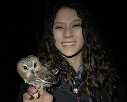 Student holding owl.