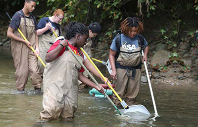 Megan Gunn demonstrates electrofishing to students at an outreach activity. 