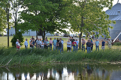 People stand around a pond at an FNR Extension event.