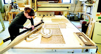 A female student works on a project in the Wood Research Lab.