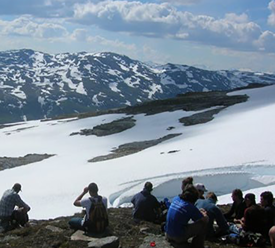 Study Abroad, students sitting in snow in the Sweden mountains.