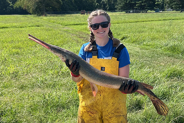 Student with sturgeon fish, Bowfishing.