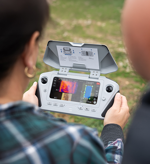 Wildlife student analyzing thermal imaging data from ground-based and drone perspectives.