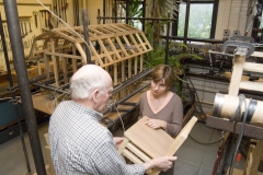 Instructors hold and review a wooden chair.