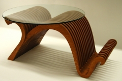 Wooden table with glass top and curved legs.