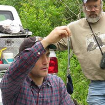 Patrick Ruhl weighing a bird during  banding. Photo by Jeff Riegel.