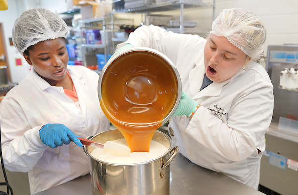 Alexandra pouring caramel into ice cream mix while working on the Boiler Chips Ice Cream project