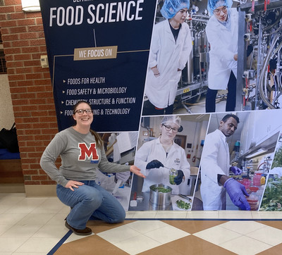 Kassandra Julian in front of her photo on the Food Science backdrop