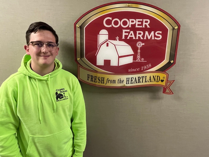Ryan Stachler in front of Cooper Farms sign